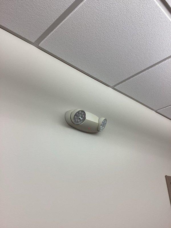 Responded to service call for non-operational emergency egress light fixture. Upon inspection, opened the dual-head LED emergency light unit and identified failed battery pack as the cause of malfunction. Replaced defective battery assembly, tested fixture operation to confirm proper illumination during emergency mode, reassembled housing, and verified unit functionality with indicator light confirmation.