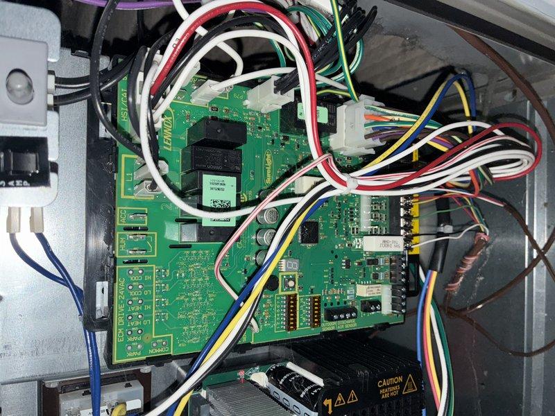 Completed recurring maintenance service on HVAC heating system. Inspected and documented air filter condition, noting pleated media with diagonal chevron pattern and securing tape in place. Examined control board assembly, verifying proper connections of multiple circuit boards with various electronic components, wire harnesses, and connector blocks all functioning within normal parameters.