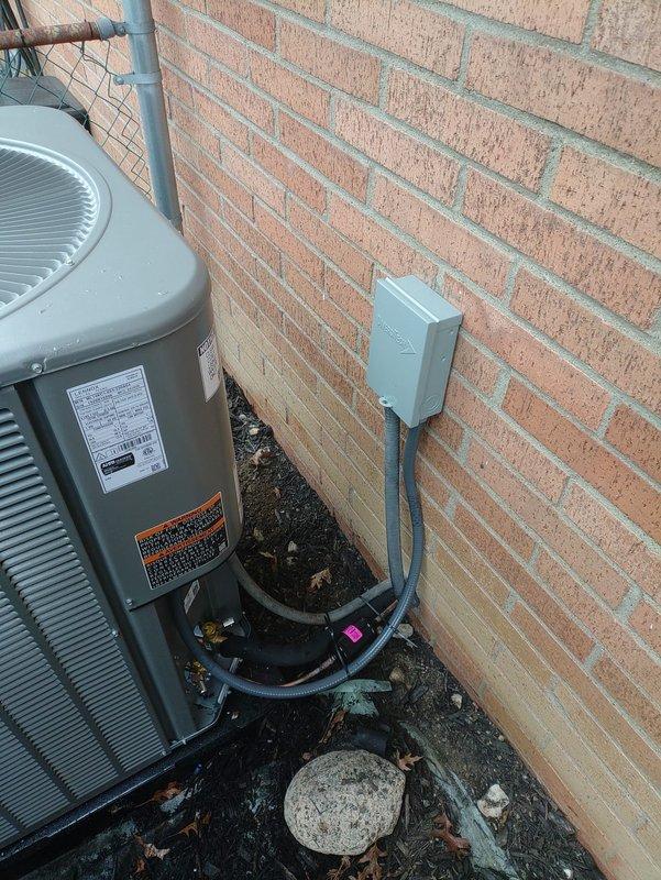 Completed full HVAC system installation including new 90% efficiency furnace and air conditioning unit. Installed outdoor condensing unit on exterior pad against brick wall with proper electrical disconnect box and conduit routing, verified 20-amp fuse protection, and ran refrigerant lines and drainage piping to interior equipment. All components tested and operational upon completion.