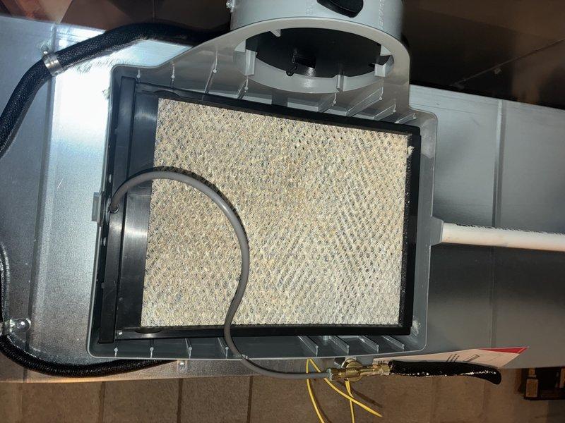 Completed comprehensive AC tune-up including inspection of electrical components and humidifier system. Removed and examined contactor assembly with dual fuses, verified proper operation and connections. Inspected humidifier evaporator pad for mineral buildup and airflow efficiency, confirmed unit accessibility and all electrical connections secure.