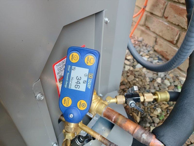 Completed full system installation of a Lennox 90% efficiency air conditioning unit at residential property. New condenser unit was positioned on black platform pad with gravel base against exterior brick wall, with proper clearances maintained for airflow and service access. All refrigerant lines, electrical connections, and condensate drainage were installed to manufacturer specifications. System was pressure tested, charged with refrigerant, and verified operational with digital gauges confirming proper temperatures and pressures across the system.