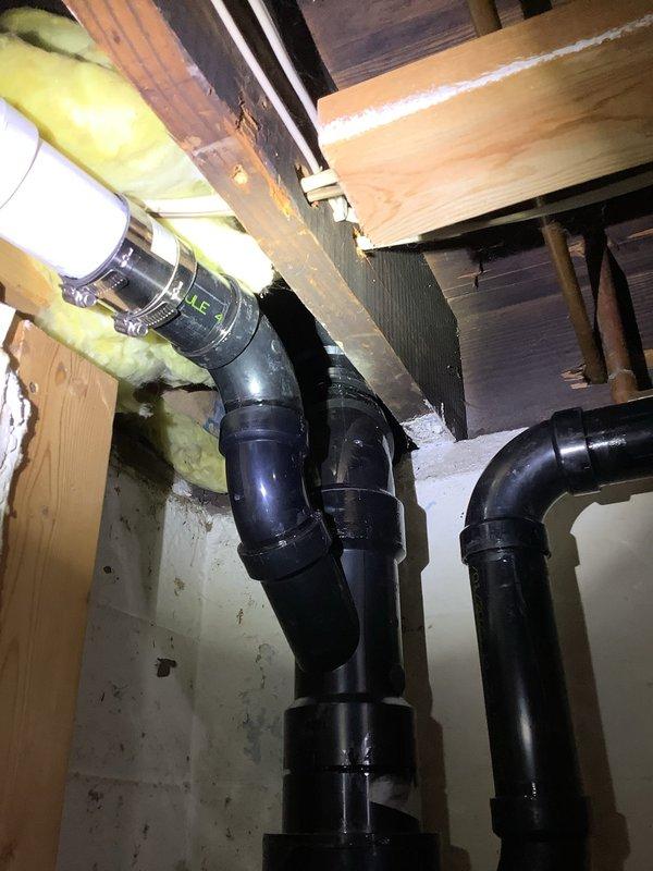 Completed extensive ABS drain pipe replacement due to broken fitting in main drainage stack. Cut out and removed compromised hub-to-hub fittings from basement through first floor offset, requiring access through kitchen cabinet back panel and basement drywall removal. Accessed crawl space to cut and remove 4" drain pipe section. Rebuilt entire drainage assembly maintaining original configuration and orientation to properly connect with existing plumbing infrastructure. Replacement parts were ordered and received prior to completion of repair work. Additionally scheduled follow-up appointment to replace expansion tank, estimated one hour duration.