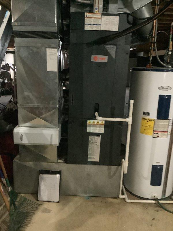 Provided comprehensive estimate for complete heat pump system replacement at residential property. Existing 14-year-old Trane air handler unit currently installed in basement utility area showing age-related wear and approaching end of serviceable life. Evaluated current system configuration including air handler, ductwork connections, condensate drainage system, and associated mechanical components. Documented equipment specifications, installation conditions, and existing infrastructure through detailed photographs of air handler unit, surrounding ductwork, PVC condensate lines, and mounting configuration. Assessed accessibility for replacement equipment installation in existing utility space alongside water heater and other mechanical systems. Quoted complete system replacement to restore efficient heating and cooling capacity for the residence.