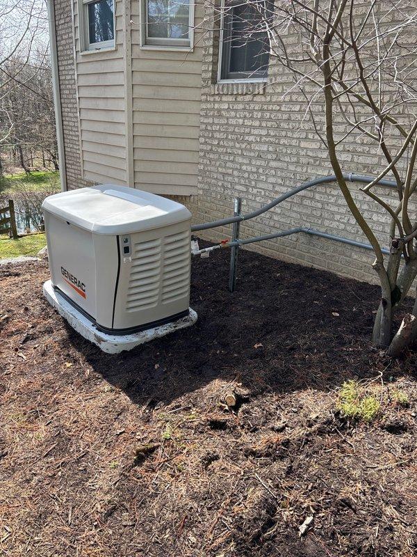 Completed installation of 26kW Generac standby generator with 200-amp automatic transfer switch and cold weather kit on concrete pad adjacent to residence. Ran approximately 25 feet of gas line from existing supply to generator location, installed electrical conduit containing copper conductors from transfer switch to generator unit, and mounted transfer switch in accordance with utility specifications. All connections tested and verified operational; no utility disconnect required per specifications.