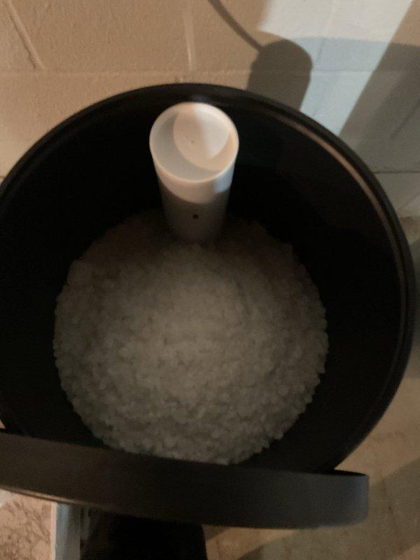 Delivered and loaded water softener salt from warehouse inventory into customer's brine tank. Verified system settings showed water hardness configured at 20 grains and confirmed proper salt level for optimal softener operation.
