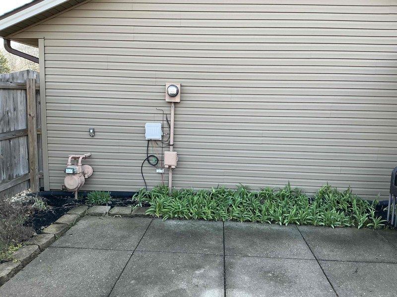 Conducted comprehensive electrical assessment for backup generator installation at residential property. Evaluated existing 200-amp main electrical panel with dual-column breaker configuration and documented current load distribution to determine integration requirements for automatic transfer switch. Inspected exterior utility connections including gas meter location and electrical service entry point to assess optimal placement for generator unit and associated conduit routing along building exterior.