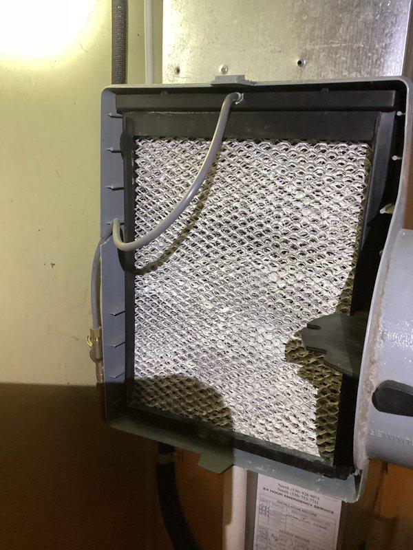 Completed routine MVP cooling maintenance visit on 13-year-old system. Inspected exterior A/C disconnect switch and verified proper operation; unit showed normal weathering consistent with age. Examined evaporative cooler pad filter assembly and noted mineral deposit accumulation and discoloration on mesh media, indicating normal usage patterns. All accessible components functioning within acceptable parameters for system age.