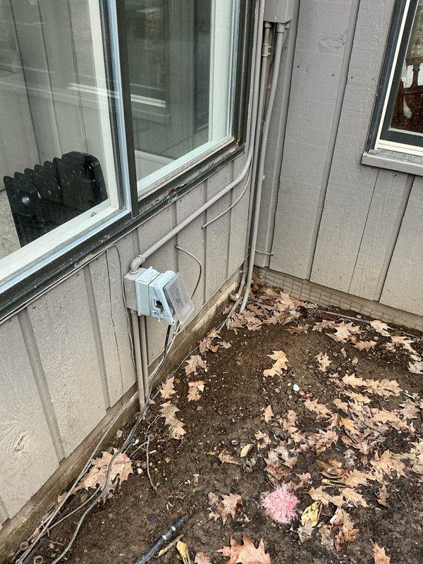 Conducted on-site evaluation for mini split installation at residential property. Assessed exterior wall locations and existing electrical infrastructure, including junction box and conduit placement on beige vinyl siding near sliding glass door. Documented installation pathway requirements and photographed proposed equipment placement areas on enclosed porch and deck spaces to determine optimal indoor and outdoor unit positioning for system efficiency.