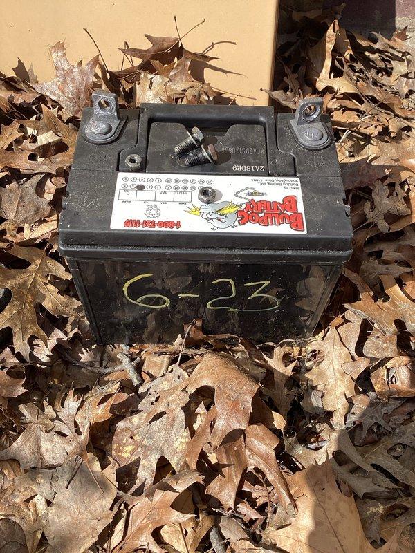 Responded to service call for non-operational Winco generator at residential property. Upon arrival, inspected 22-year-old generator unit located on exterior of building. Found failed battery preventing generator from starting. Removed deteriorated battery dated 6-23 from unit. Replaced with new battery, restored generator to proper working condition, and verified successful operation through startup test.