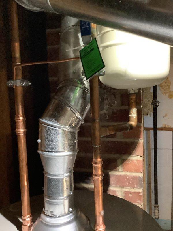 Removed and replaced corroded galvanized bathroom drain line by opening wall above basement toilet to access the connection point. Cut existing drain line at cast iron connection, chiseled out old pipe from cast iron wye fitting, and installed Jones gasket to transition from cast iron to plastic. Ran new PVC drain line to connect with existing vertical drop for lavatory, ensuring proper tie-in to existing PVC drainage system. Installed new 40-gallon short Bradford White water heater with 6-year manufacturer warranty, complete with new thermal expansion tank for system protection.