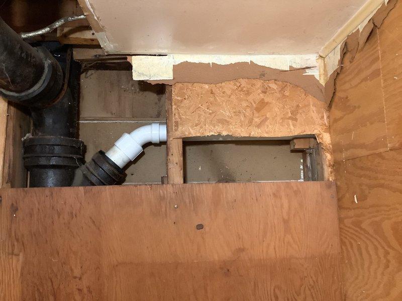 Removed and replaced corroded galvanized bathroom drain line by opening wall above basement toilet to access the connection point. Cut existing drain line at cast iron connection, chiseled out old pipe from cast iron wye fitting, and installed Jones gasket to transition from cast iron to plastic. Ran new PVC drain line to connect with existing vertical drop for lavatory, ensuring proper tie-in to existing PVC drainage system. Installed new 40-gallon short Bradford White water heater with 6-year manufacturer warranty, complete with new thermal expansion tank for system protection.