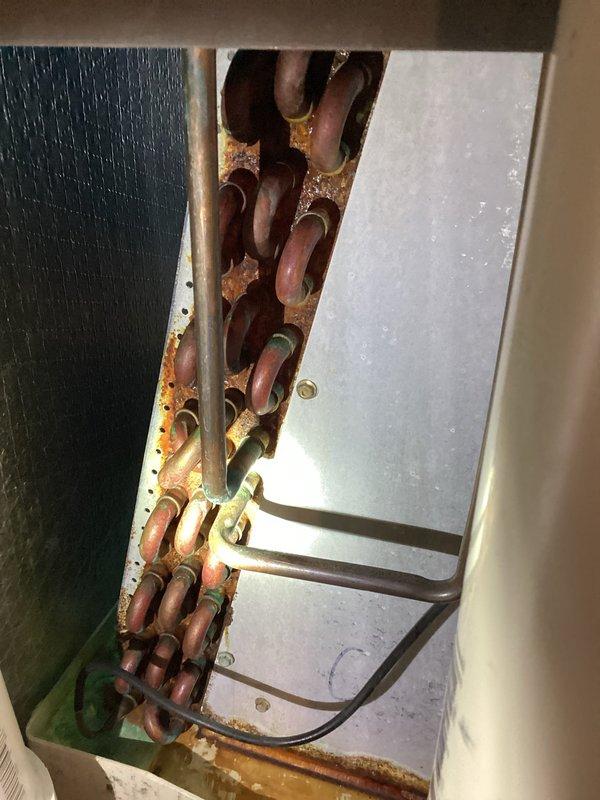 # HVAC Maintenance - Cooling

Completed MVP cooling maintenance visit on residential HVAC system. Upon inspection, discovered significant corrosion and rust deterioration on copper refrigerant lines within the air handler cabinet, indicating prolonged moisture exposure and potential system efficiency concerns. Documented equipment condition with detailed photographs showing corroded copper tubing, internal cabinet components, furnace blower assembly, and electrical connections. Inspected gas valve, control mechanisms, and wiring harnesses for proper operation. Verified PVC condensate drain line positioning and mounting. System components photographed include blower motor, electrical connections, safety labels, and internal framework to provide comprehensive maintenance record for ongoing service tracking.