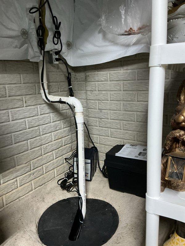 Responded to emergency service call for failed primary sump pump with activated backup battery system. Upon arrival, conducted thorough inspection of existing sump pump installation and determined main pump had reached end of service life and required immediate replacement. Removed failed primary sump pump unit from basin and cleared debris from sump pit to ensure proper operation of new equipment.

Installed new residential-grade sump pump in existing basin with appropriate discharge piping configuration. Connected white PVC discharge line using proper primer and cement techniques, ensuring all joints were secure and leak-free. Verified proper float switch operation and pump activation at correct water levels. Secured all electrical wiring with zip ties and organized cables along existing pipe runs to maintain clean installation appearance.

Tested backup battery sump pump system to confirm operational readiness and verified battery charge level was adequate for extended power outage 