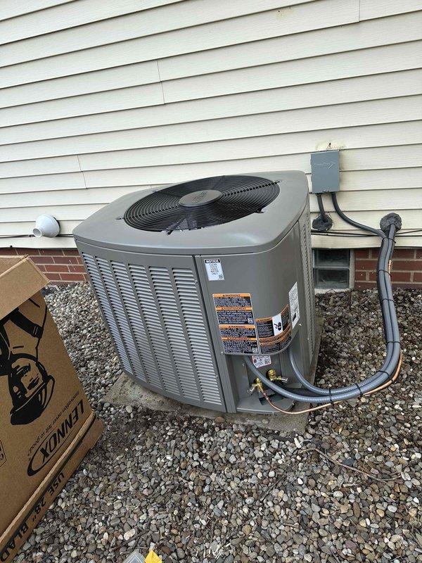 Completed full HVAC system installation including new 90% efficiency furnace and air conditioning condenser unit. Installed outdoor AC unit on gravel pad with proper clearances, connected refrigerant lines to house, mounted electrical disconnect box with 25A fuses on exterior wall, ran electrical conduit and wiring to unit, and installed new flue venting system for high-efficiency furnace. All electrical connections secured, system tested and verified operational.