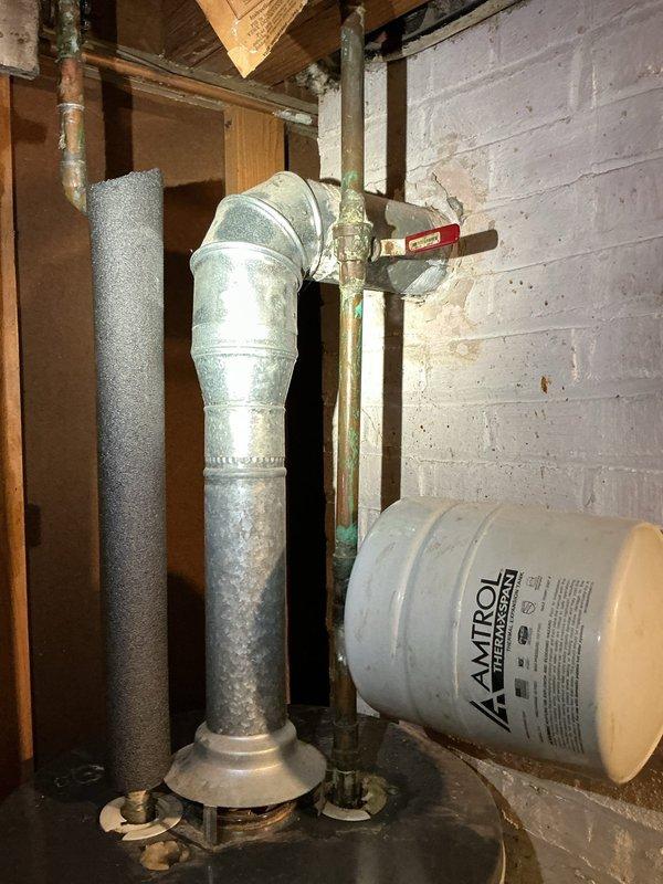 Responded to service call for leaking water heater in residential property over 40 years old. Upon inspection, confirmed active leak from existing water tank requiring immediate replacement. Assessed attic/crawl space installation location with existing plumbing infrastructure including copper water lines, shutoff valves, and venting system showing age-related corrosion and deterioration. Documented existing conditions including corroded vent piping with significant discoloration and greenish patina on metal components indicating extended moisture exposure. Provided estimate for new water heater installation, discussed available financing options and membership program benefits with customer. Established new service account per customer request and scheduled follow-up for installation.