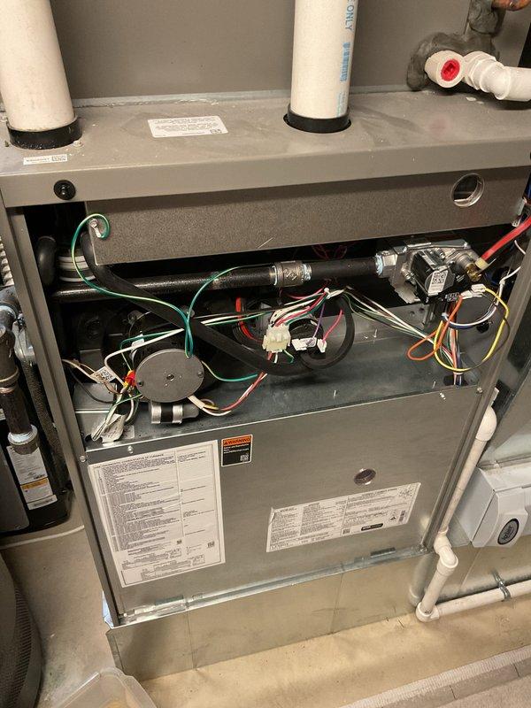 Responded to no heat call on five-year-old furnace with no airflow. Upon inspection, found unit completely non-operational with gas valve assembly and control board accessible for diagnostics. Verified proper venting configuration with PVC intake and exhaust pipes, checked all electrical connections at gas valve terminals, and inspected pressure switch and safety circuits. All wiring harnesses, including thermostat wiring and limit switch connections, were examined for continuity and proper seating. Unit components appeared clean and well-maintained with no visible signs of wear or damage to internal mechanisms.