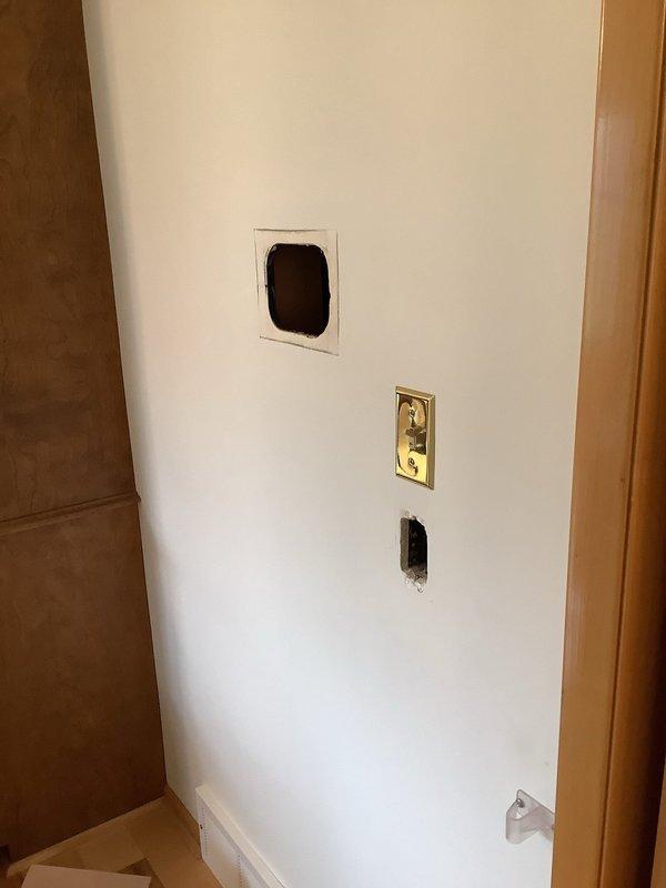 Removed existing dining room and back room light fixtures and installed fandelier units at both locations utilizing pre-existing metal junction boxes. Fished new electrical line from living room outlet near television location, routing power down through wall cavity and back up to newly installed two-gang box behind TV for entertainment console integration. Removed complete intercom system including main control unit and four remote stations throughout residence, traced and disconnected power source, and cut back all associated low voltage wiring. Replaced doorbell system with new unit and relocated chime to entry closet for concealment.