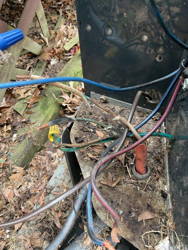 Responded to no cooling complaint on 12-year-old outdoor condensing unit. Upon arrival, found unit blowing warm air and discovered significant debris accumulation throughout the equipment, including dried leaves, twigs, and organic matter collected inside the cabinet and around internal components. Removed access panel to inspect electrical connections and compressor circuit. Located dual-run capacitor with multiple wire terminations showing signs of environmental exposure. Observed heavy dirt and grime buildup on contactor assembly and wiring connections. Cleaned debris from unit interior and base, removed organic material affecting airflow and component operation. Inspected all electrical connections including capacitor terminals with red, yellow, and black wire leads. Verified proper wire terminations and connection integrity on contractor and capacitor. Cleared PVC condensate drain lines of blockage potential. Assessed overall unit condition noting exterior weathering consistent wi