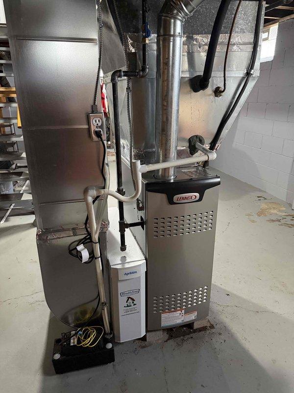 Completed installation of Lennox 80% AFUE furnace system in basement utility area. Installed new furnace unit with associated ductwork connections, PVC condensate drain lines, and electrical wiring. Connected furnace to existing air handler/evaporator coil assembly with metallic supply ductwork, ensuring proper airflow and system integration. All components secured, tested, and operational.