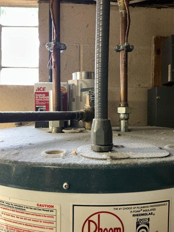 Responded to service call for 15-year-old electric water heater not producing hot water. Upon assessment, determined unit required replacement per customer request. Completed full water heater replacement, installing new Rheem electric tank unit in basement utility area. Disconnected existing copper supply lines, drained old tank, and removed from service. Installed replacement unit with proper connections to existing plumbing infrastructure, including hot and cold water copper lines secured to overhead framing. Verified all electrical connections via flexible metallic conduit, ensured proper grounding, and tested unit operation. System restored to full functionality with hot water delivery confirmed.