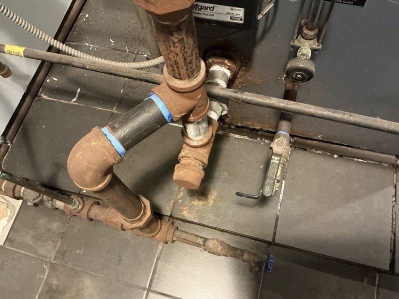 Conducted comprehensive boiler system evaluation and documented existing conditions for financing assistance application. Assessment revealed aging plumbing infrastructure with extensive corrosion on copper piping, deteriorated pipe fittings, and oxidized components throughout the heating system. Photographed overhead piping configuration, pressure gauges, shut-off valves, and basement mechanical systems to support loan application documentation for equipment replacement.