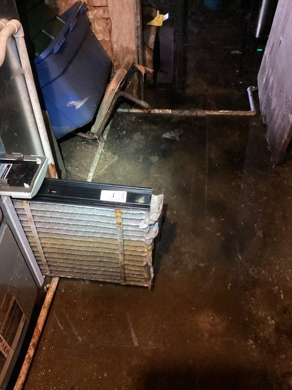 Responded to no-heat call on Lennox furnace in flooded basement. Upon arrival, found standing water throughout utility area due to recent flooding, which had compromised the air filter and affected system operation. Inspected furnace and surrounding components, noting water damage to basement space and corroded copper piping. Replaced water-damaged air filter with new unit. Verified furnace restored to proper operation and heating capability. Documented flood conditions and equipment status with photos for customer records.