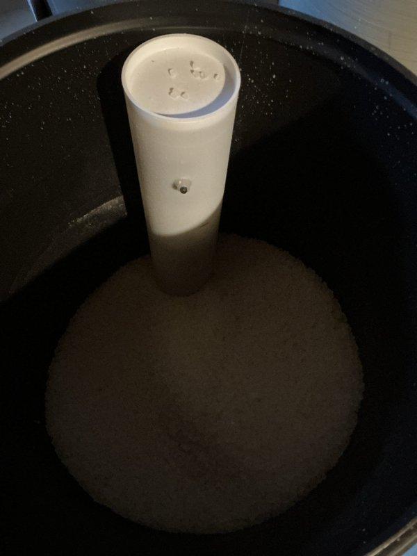 Delivered four bags of professional-grade solar salt to the residence and assisted with loading the water softener system. Inspected the water softener tank and brine basin, noting normal sediment accumulation in the sump pit and proper standpipe positioning. Successfully replenished salt supply to ensure continued operation of the water treatment system.