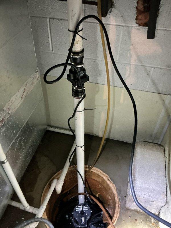 Responded to basement flooding emergency caused by failed primary sump pump and battery backup system. Removed existing dual-pump configuration including deteriorated primary pump, battery backup unit, and associated discharge piping. Installed new submersible sump pump with check valve assembly in existing concrete floor pit, secured vertical PVC discharge line with proper mounting hardware, and reconfigured plumbing to eliminate backup system per customer approval. Tested pump operation and float switch functionality to ensure proper activation and discharge flow.