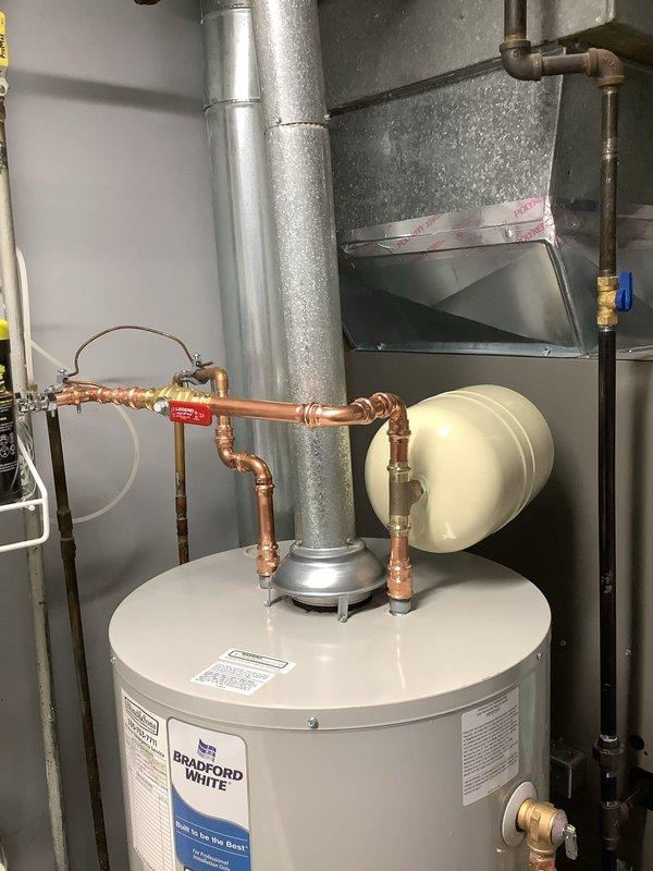 Installed a 40-gallon short Bradford White water heater with all required code upgrades, including proper expansion tank installation with copper piping, brass fittings, and pressure relief valve. The installation was completed in a residential utility space with proper connections to existing plumbing systems, ensuring compliance with current plumbing standards and manufacturer specifications for professional installation.