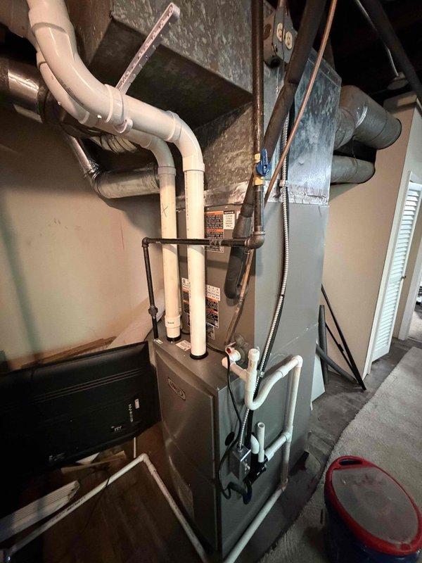 Completed full HVAC system installation in basement mechanical room, including new furnace/air handler unit and associated components. Installed and connected refrigerant lines, PVC condensate drain and vent piping, and integrated metal ductwork transitioning from rectangular to round configuration extending through ceiling joists. All equipment properly labeled, secured, and tested for operational functionality per manufacturer specifications.