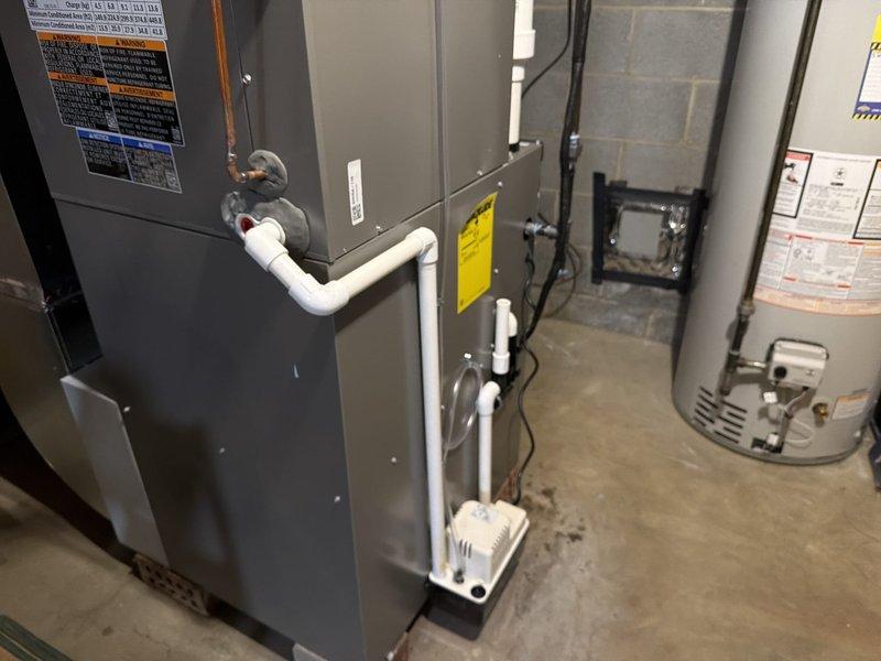 Completed installation of a new Lennox 3-ton air conditioning system with model EL16KCT-036-230A01 utilizing R-454B refrigerant and achieving a minimum EER2 efficiency rating of 12.2. The outdoor condensing unit was installed and properly connected to the existing indoor air handler located in the basement utility area. All electrical connections were completed per manufacturer specifications with 200/230V single-phase power supply, verified proper voltage parameters, and confirmed compressor RLA of 16.7 and LRA of 93.5. Refrigerant lines were connected, pressure tested to 640 PSIG, evacuated, and charged to factory specifications. Condensate drain lines were routed using white PVC piping with proper trap installation to ensure adequate drainage. System was started up, operational testing performed to verify proper compressor and fan motor operation, and all safety controls were confirmed functional.