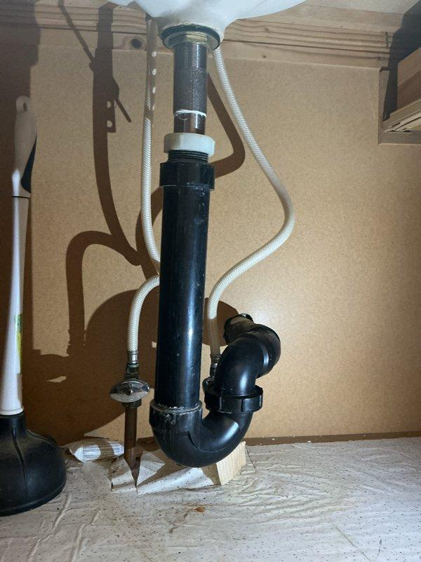 Responded to service call for clogged pipe under hallway sink. Upon inspection, identified blockage in the P-trap assembly beneath the sink. Disassembled the drain system, cleared the obstruction from the black PVC P-trap, and verified proper drainage flow through the chrome strainer basket and tailpiece connection. Reassembled all plumbing components, ensuring proper seal at all connection points, and tested the system to confirm full functionality and no leaks.