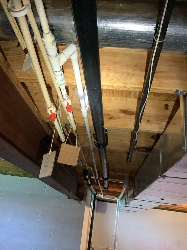 Conducted complimentary second opinion assessment of existing sump pump system in basement utility area. Performed thorough inspection of sump pump installation, including examination of discharge piping configuration with white PVC components, check valve assembly with red-handled shutoff valve, and drainage routing. Evaluated overall plumbing infrastructure in unfinished basement space, noting exposed floor joists, existing HVAC ductwork, and mechanical systems layout. Documented current system condition through photographic evidence showing pump location, piping arrangement, and surrounding utility connections. Provided professional assessment and recommendations regarding repair versus replacement options based on observed equipment condition and installation setup.