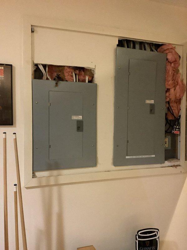 Responded to service call regarding separated conduit connection at primary electrical meter. Upon arrival, confirmed that utility company required licensed electrician to address the meter conduit separation before reconnecting service. Inspected dual electrical panel installation in recessed wall cavity and verified all circuit breaker connections and panel integrity. Documented existing conditions showing panels properly mounted with exposed insulation in surrounding wall opening, indicating active renovation work. All circuit breakers tested and confirmed operational in both panel boxes.