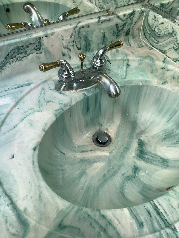 Responded to service call for running toilet and dripping faucet in two separate bathrooms. Inspected toilet fill valve assembly and flapper mechanism to diagnose continuous running issue. Examined faucet cartridge and supply line connections at vanity sink with turquoise marbled countertop to identify source of drip. Evaluated water supply plumbing including flex lines, shut-off valves, and copper piping. Provided customer with repair recommendations and options for both fixtures to restore proper operation and eliminate water waste.