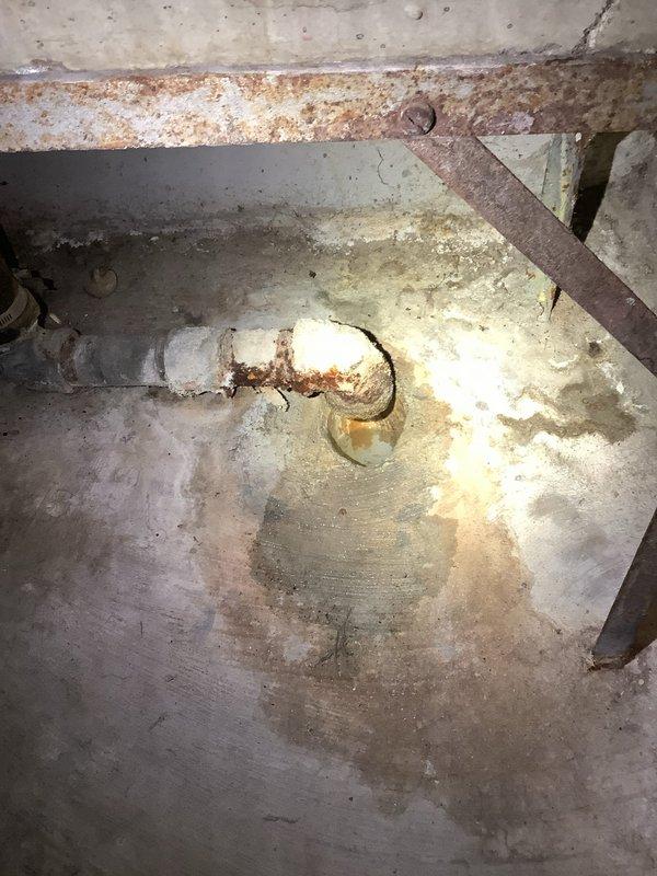 Responded to basement drainage issue where water was backing up through floor drain, preventing use of washing machine. Upon arrival, located main floor drain access point in basement with visible signs of chronic backup and water damage to surrounding concrete. 

Removed corroded drain cover and inspected drain assembly. Found severely deteriorated trap and drain line with significant rust accumulation and mineral buildup restricting water flow. Standing water in line confirmed blockage was causing backup into basement when washing machine discharged.

Cleared obstruction from main drain line using mechanical cable auger. Removed accumulated debris, soap residue, and sediment from trap assembly. Flushed line thoroughly to restore proper drainage and verify water flow. Tested system by running water to confirm backup issue resolved and drainage functioning correctly. Customer advised that washing machine can now be operated normally without water returning through floor drain.