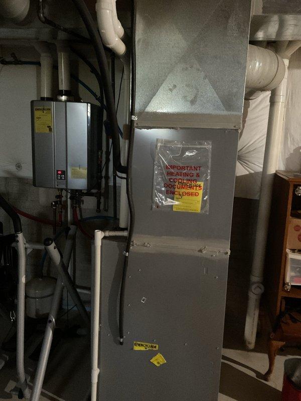 Responded to service call for sump pump backup issues. Upon inspection, found sump pump experiencing recurring drainage problems despite previous flushing attempts. Evaluated sump pump assembly, discharge piping, and check valve system for blockages or mechanical failure. Assessed condition of existing pump motor and float switch operation. Photographed installation showing sump basin, electrical connections, copper and PVC discharge lines, and associated plumbing infrastructure in basement utility area. Discussed diagnostic findings with customer and provided recommendations for either snaking the discharge line to clear potential obstruction or replacing the sump pump unit depending on severity of blockage and pump condition.