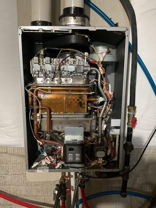 Performed complete flush and fill maintenance service on wall-mounted tankless water heater unit. Removed and cleaned inlet filter screen which showed significant sediment accumulation and debris buildup. Flushed heat exchanger assembly and internal copper piping system to remove mineral deposits and restore optimal flow rates, then refilled unit and verified proper operation of all components including gas valve assembly and control module.