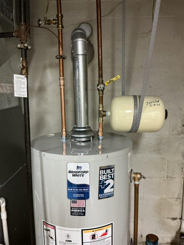 Removed existing residential water heater and installed new Bradford White replacement unit in basement utility area. Replaced thermal expansion tank during installation and verified all existing components meet current code requirements. Connected copper supply lines with brass fittings and valves, installed proper venting system, and confirmed all plumbing connections are secure and operational. Unit includes 8-year manufacturer warranty and all safety labels properly affixed.