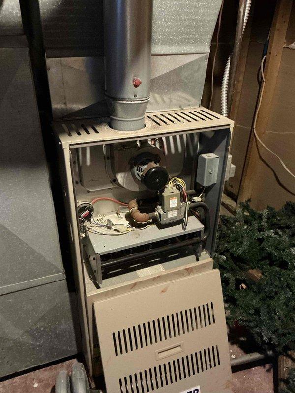 Conducted on-site assessment for air conditioning installation estimate at property with no existing AC system. Evaluated 25-year-old existing furnace for potential replacement, documenting current equipment condition through detailed photography of internal components including gas valve, ignition system, blower assembly, and associated wiring. Observed significant condensation accumulation on main trunk ductwork, indicating potential insulation deficiency that would need to be addressed during AC installation to prevent efficiency loss and moisture issues. Provided comprehensive replacement options for both cooling system addition and furnace upgrade to modernize complete HVAC system.