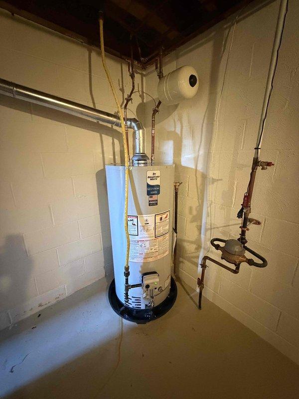 Completed installation of a 90% efficiency furnace and residential water heater in basement mechanical room. Installed new water heater with proper plumbing connections including copper supply and discharge lines, gas line connections using approved flexible connectors, and appropriate safety devices. Mounted expansion tank on wall above unit and installed water heater on code-compliant drip pan. Installed Kidde carbon monoxide alarm with hardwired power connection to provide safety monitoring for combustion appliances. All installations completed per manufacturer specifications and local building codes, with proper venting, gas connections, and safety shutoff valves in place.