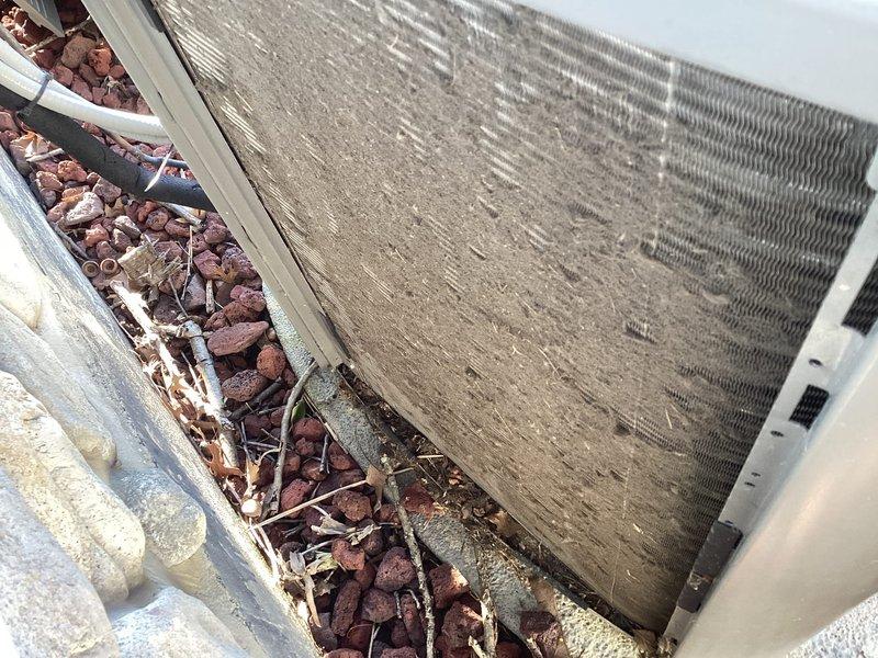 Completed MVP recurring cooling maintenance visit. Inspected outdoor condenser unit and found coils heavily contaminated with dust, dirt, and debris accumulation, significantly impacting heat transfer efficiency. Documented excessive buildup on finned coils and surrounding area with plant debris present in landscaping rocks. Inspected indoor air handler and found air filter heavily soiled with dust and particulate matter throughout the mesh media. Filter condition indicated restricted airflow and reduced system performance. Documented both components' conditions for maintenance records.