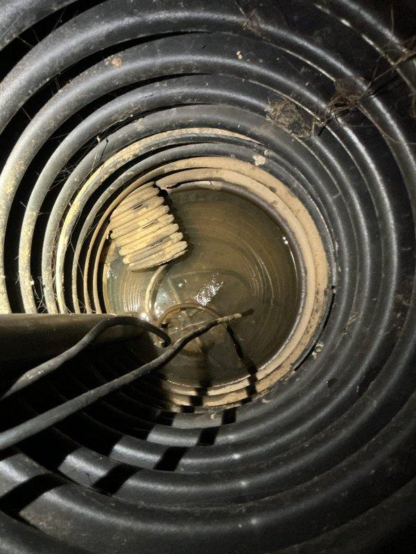 Responded to service call for non-operational sump pump in residential basement. Upon inspection, confirmed existing pump had failed and was no longer functioning. Standing water was present in the sump pit with visible sediment accumulation. Removed failed pump unit from pit and installed new replacement sump pump system. Connected discharge piping with insulated vertical pipe configuration. Verified proper electrical connections and tested pump operation to ensure adequate water removal and automatic float switch functionality. System restored to full working order.