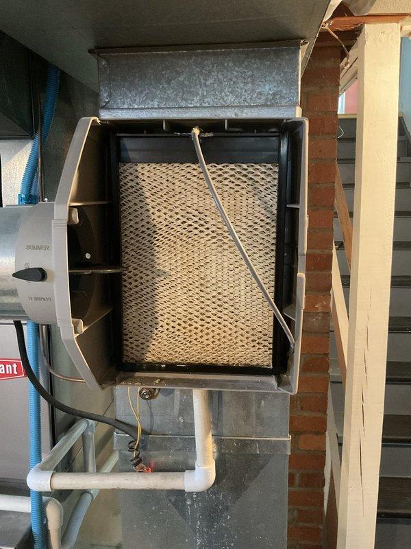 Completed routine air conditioner maintenance checkup for residential HVAC system. Performed comprehensive inspection of cooling equipment, verified proper operation of all components, and examined humidifier unit mounted on main ductwork with evaporator pad showing normal condition. Inspected and evaluated air filter condition, confirming adequate filtration media for continued system efficiency.