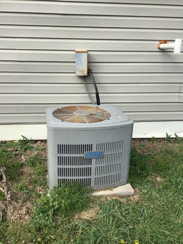 Conducted comprehensive evaluation of existing HVAC system for replacement estimate. Documented current equipment configuration including furnace interior components with model XL0376-601119 operating instructions and speed selection specifications. Assessed outdoor condensing unit condition, noting weathered cylindrical unit with vertical louvered panels positioned on concrete pad against exterior wall. Photographed refrigerant line routing from condensing unit through white protective conduit mounted to vinyl siding. Evaluated overall system age, condition, and replacement requirements to provide accurate equipment sizing and installation scope recommendations.