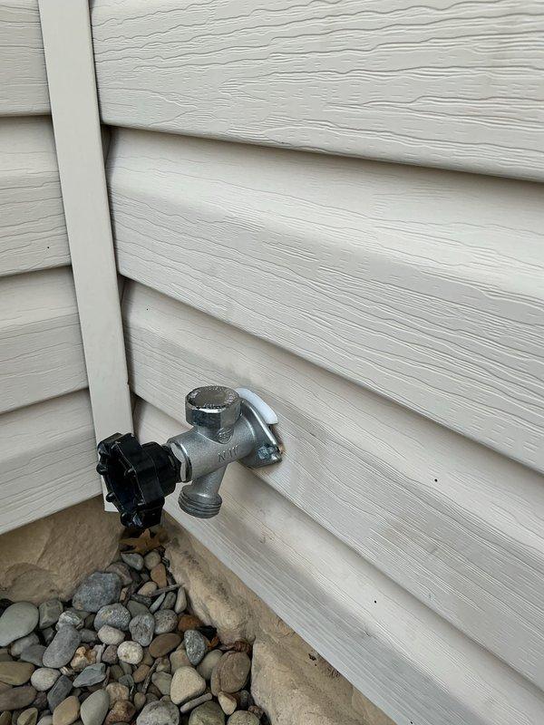 Responded to service call for two outdoor spigots that had cracked after installation in 2023. Performed site assessment and provided quote for complete replacement of both failed exterior hose bibs. Inspection revealed frost damage to the existing fixtures mounted on vinyl siding exterior. Documented current condition of Y-shaped spigot valve with chrome finish and identified necessary replacement specifications to prevent future freeze-related failures.