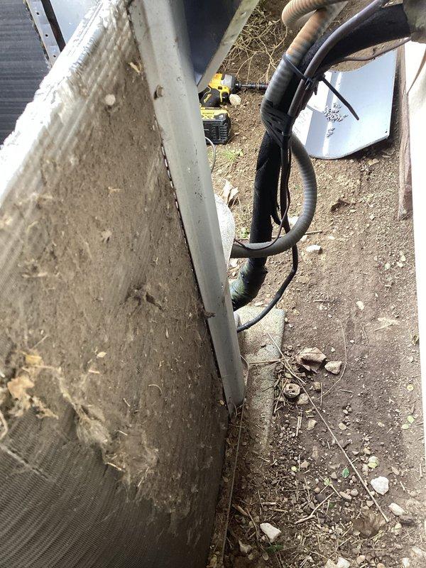 Responded to service call for furnace making loud noise following recent maintenance. Upon inspection, identified blower assembly as source of noise concern. Examined outdoor HVAC unit and found condenser coil heavily clogged with dirt, dust, and debris accumulation, significantly restricting airflow. Documented equipment condition showing substantial buildup on heat exchanger fins and weathered exterior components requiring attention.