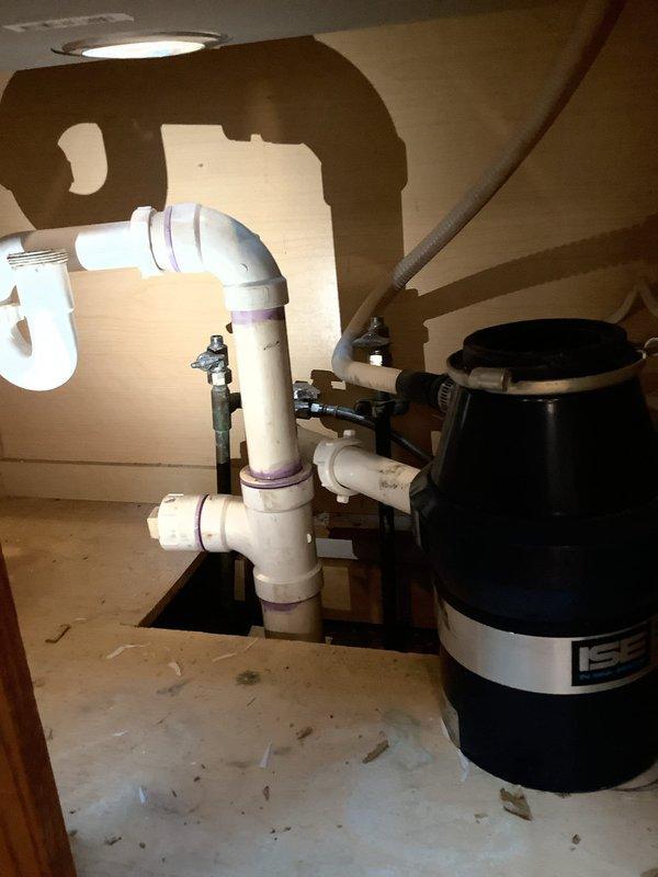 Completed kitchen sink conversion from double-basin to single-basin configuration with new undermount stainless steel sink installation. Installed garbage disposal unit and reconfigured drain plumbing with PVC P-trap assembly to accommodate new sink layout. Provided quote for whole house water filtration system as requested.