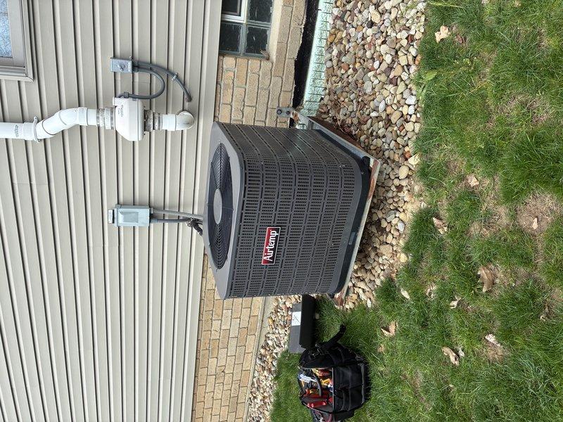 Responded to no cooling complaint on 15+ year old residential air conditioning system. Upon arrival, performed diagnostic assessment of Coleman/Bryant condenser unit and associated components. Inspected outdoor unit positioned on concrete pad, verified proper electrical connections, examined refrigerant line sets, and checked PVC condensate drainage system. Identified issue preventing cold air production and completed necessary repairs to restore system operation. Customer enrolled in maintenance program with service charge waived as membership benefit. Unit tested and verified cooling functionality upon completion.