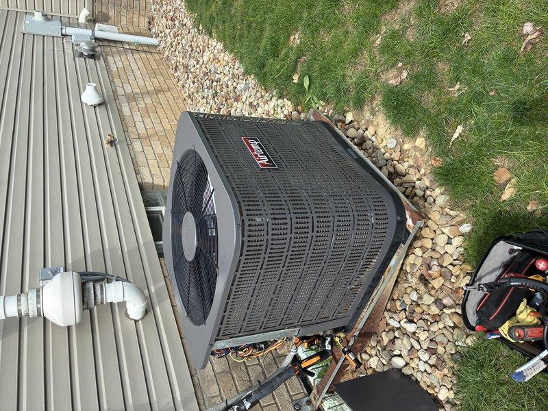 Responded to no cooling complaint on 15+ year old residential air conditioning system. Upon arrival, performed diagnostic assessment of Coleman/Bryant condenser unit and associated components. Inspected outdoor unit positioned on concrete pad, verified proper electrical connections, examined refrigerant line sets, and checked PVC condensate drainage system. Identified issue preventing cold air production and completed necessary repairs to restore system operation. Customer enrolled in maintenance program with service charge waived as membership benefit. Unit tested and verified cooling functionality upon completion.